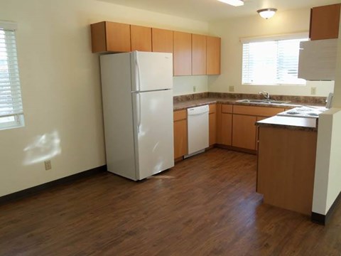 A kitchen with a white refrigerator and wooden cabinets.