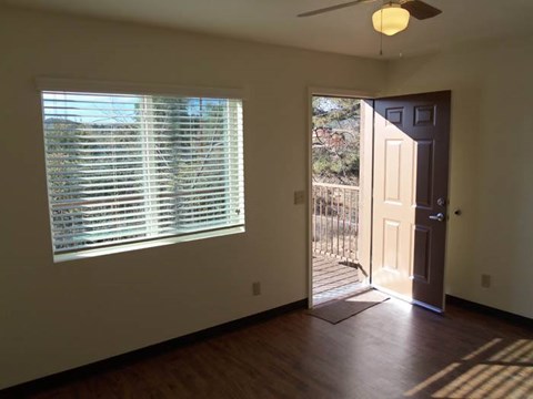 A room with a brown door and a window with blinds.