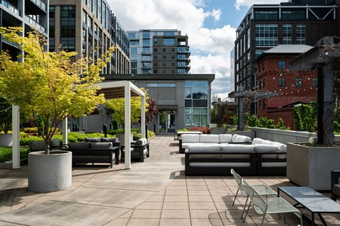 A patio with a table and chairs is surrounded by buildings.