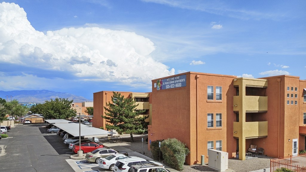 A parking lot with cars and a building with a sign on it.