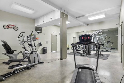 A gym with treadmills, exercise bikes, and other equipment.