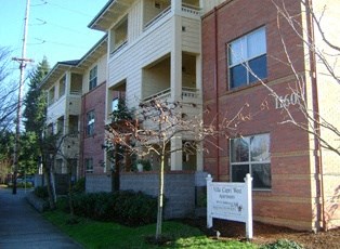 an apartment building with a sign in front of it