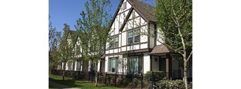 a house with a fence and trees in front of it