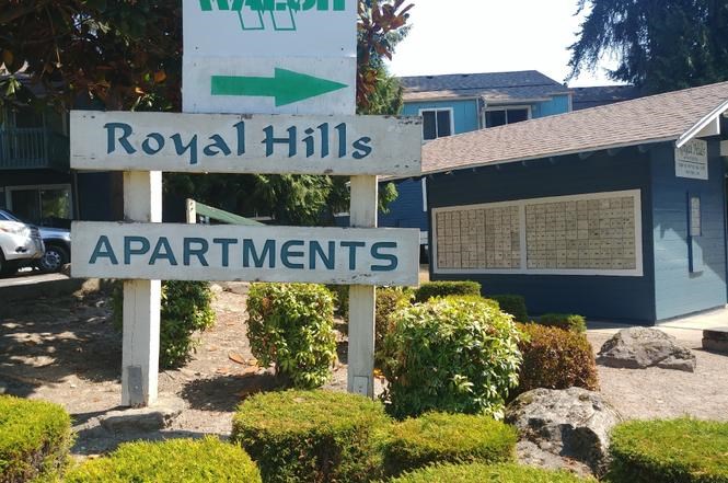 A sign for Royal Hills Apartments is shown in front of a building.