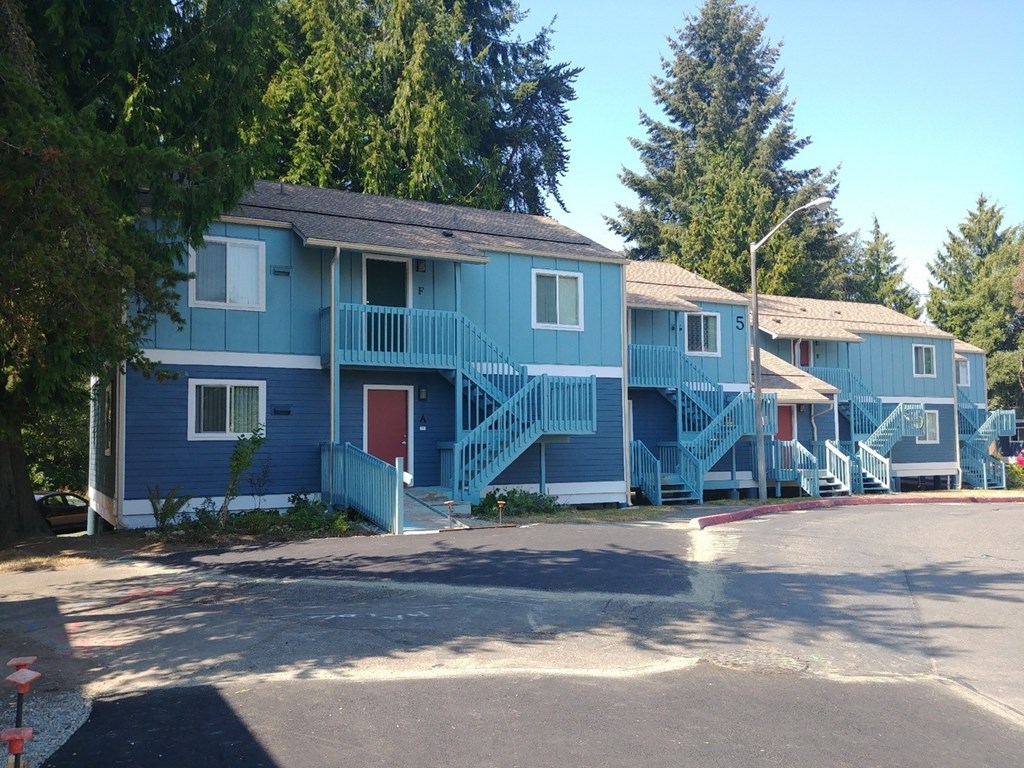 A blue house with a red door and a balcony.