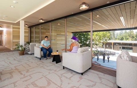 Two people sitting on a couch in a room with a tiled floor.