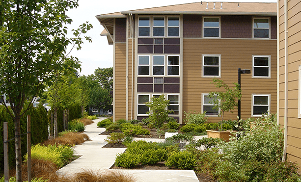 an apartment building with a garden in front of it