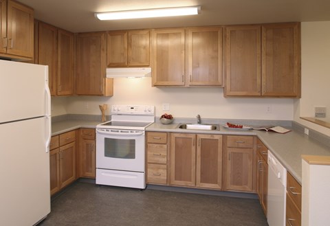 A kitchen with wooden cabinets and white appliances.