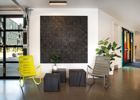 a living room with yellow chairs and a black wall