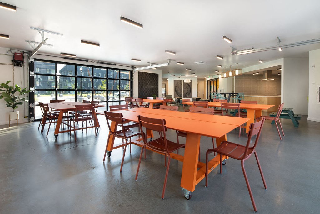 a large room with orange tables and chairs