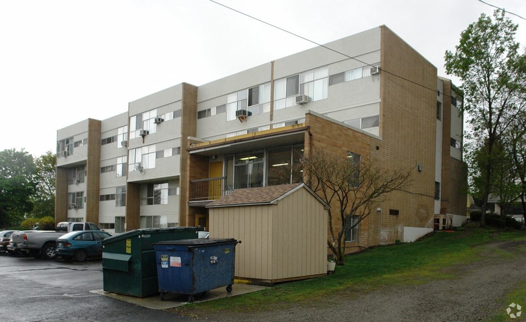 A large apartment building with a dumpster in front of it.