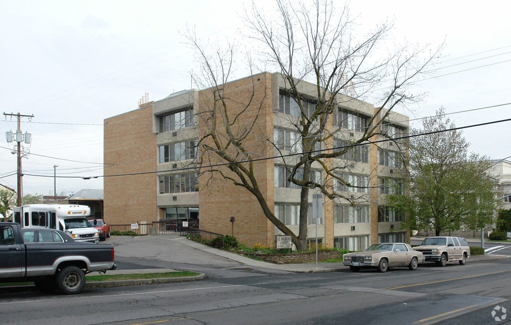 A large brick building with a tree in front of it.