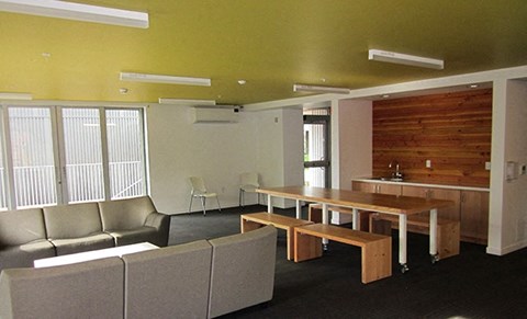 a room with couches a table and chairs and a kitchen
