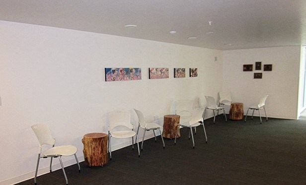 a room with white chairs and tables and pictures on the wall