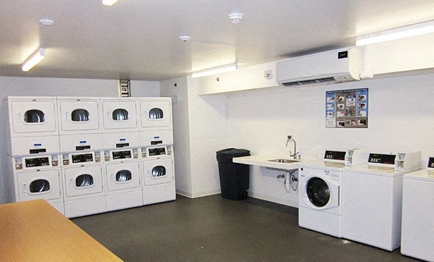 a laundry room with washes and dryers and a counter with a counter top