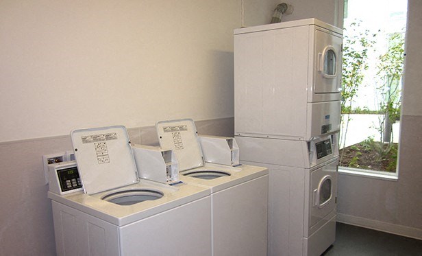 a laundry room with two washing machines and a refrigerator