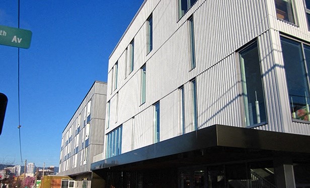 the side of a building with a street sign in front of it