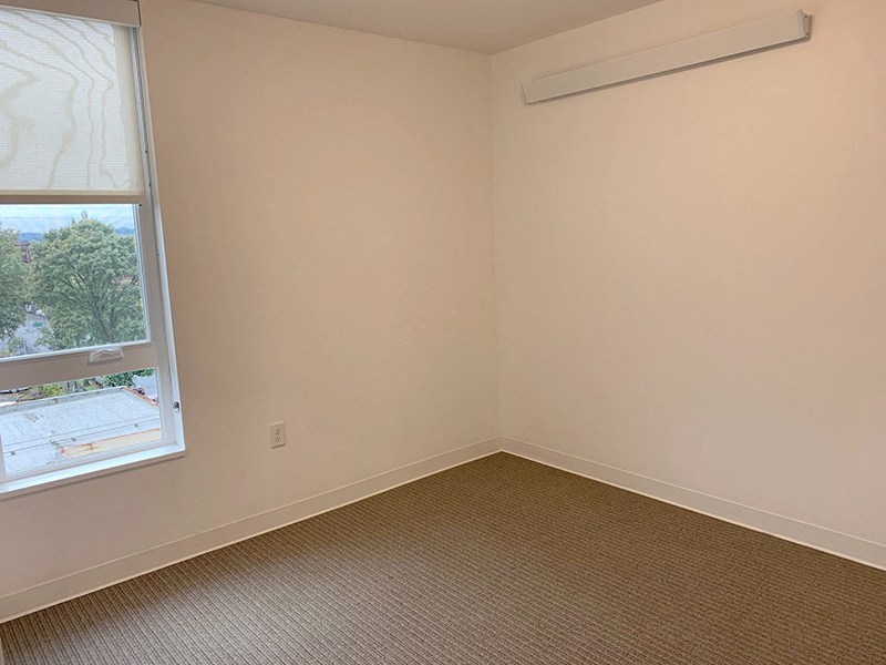 an empty room with a window and a carpet