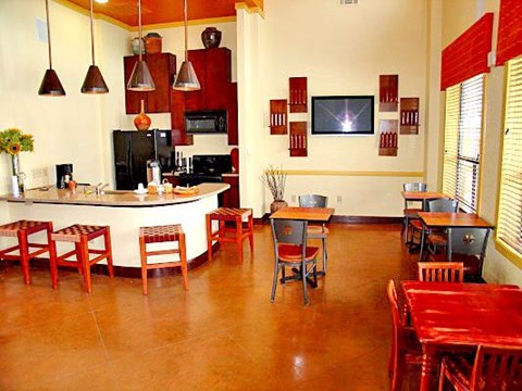 a large room with tables and chairs and a kitchen