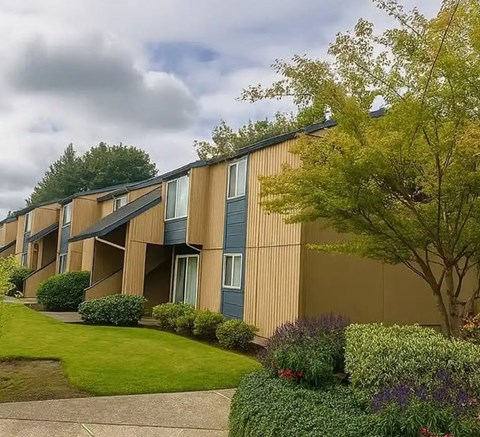 Apartment building with a green lawn in front.