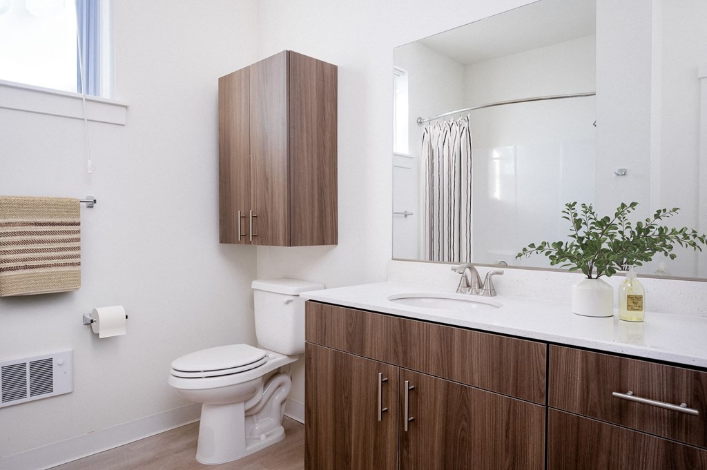 A white toilet sits next to a white sink in a bathroom.