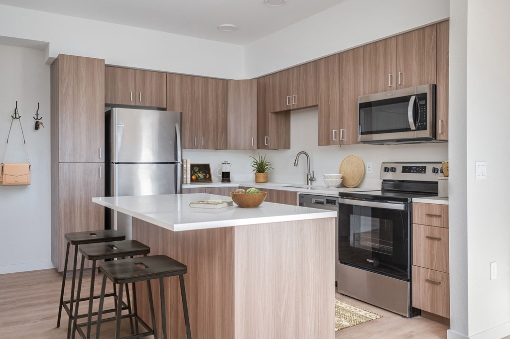 a kitchen with a large island and stainless steel appliances