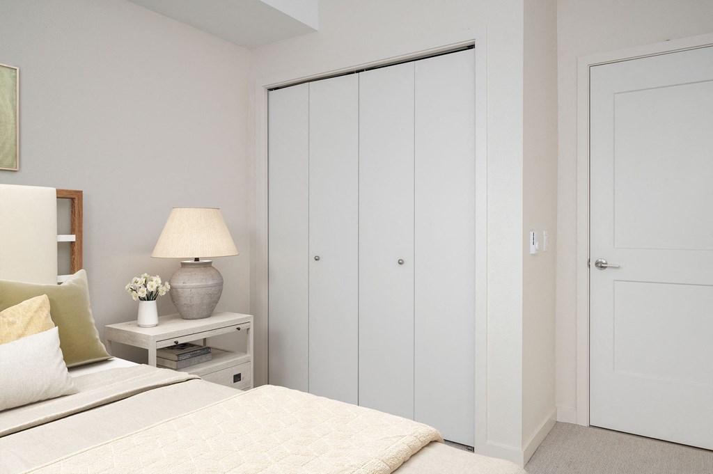 a bedroom with a bed and a nightstand with a lamp