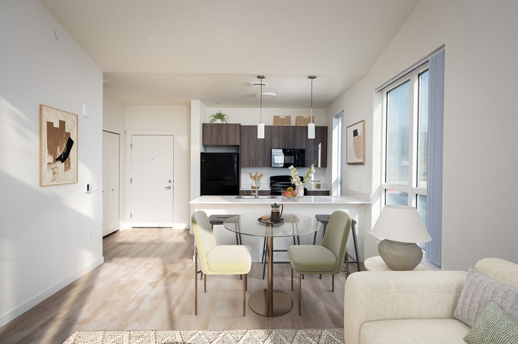 A modern living room with a kitchen in the background.