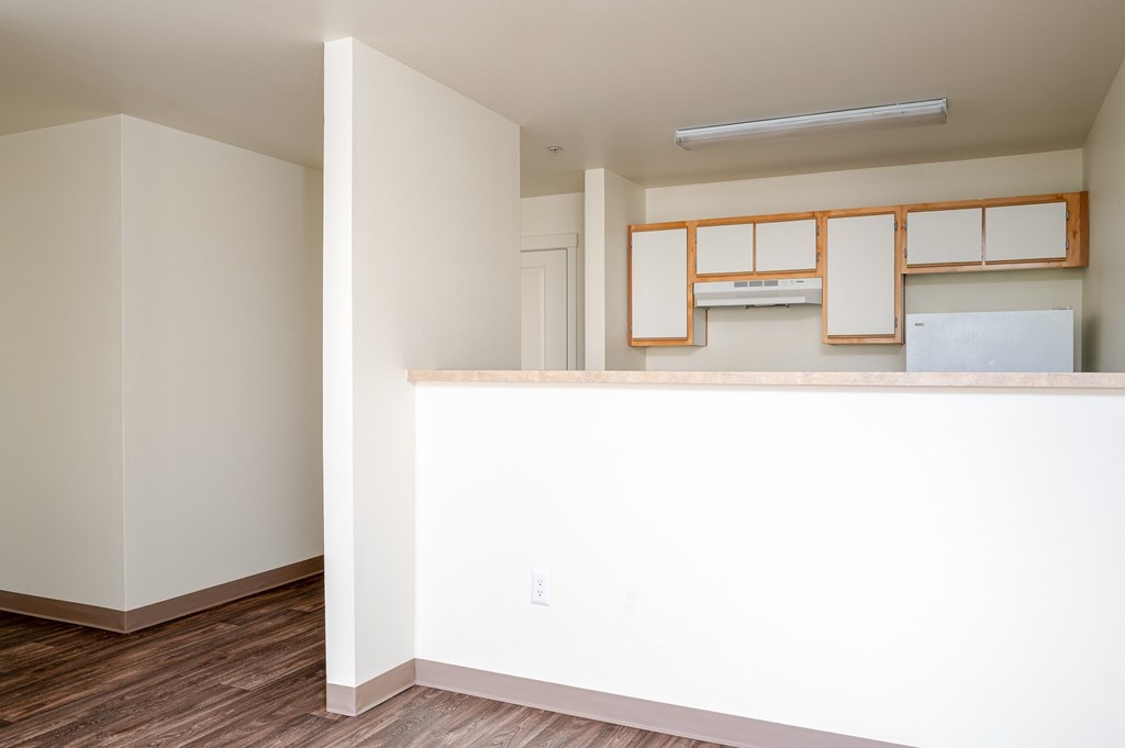A kitchen with white cabinets and a white fridge.