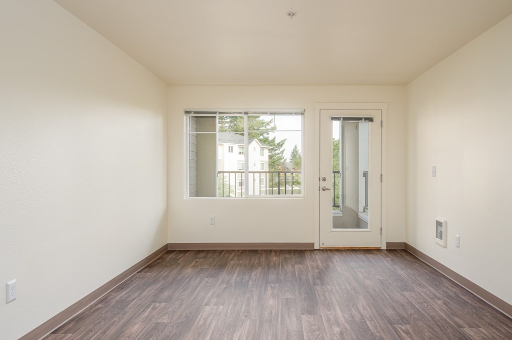 A room with a wooden floor and a sliding glass door.