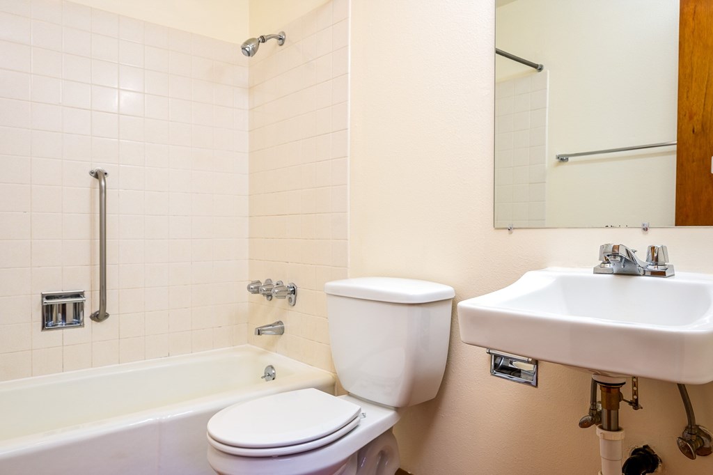 A white toilet sits next to a white sink in a bathroom.