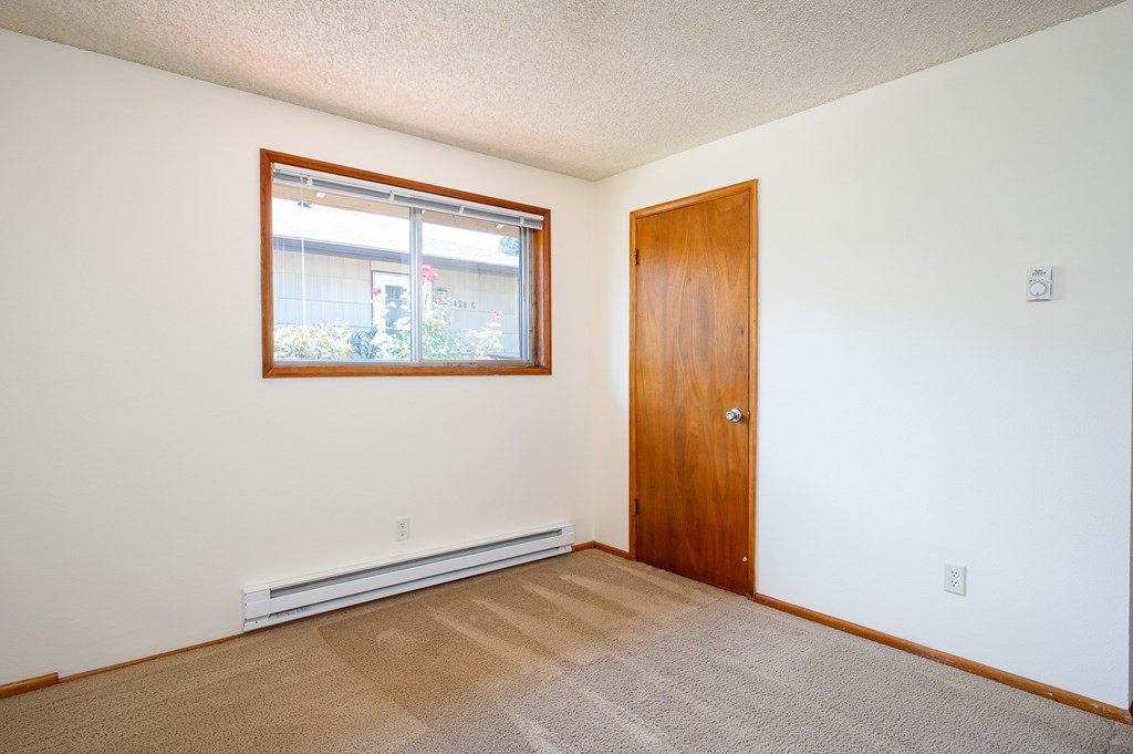 A room with a door, window, and carpet.