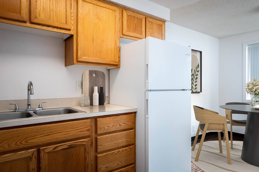 a kitchen with a sink and refrigerator and a dining room table