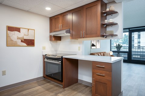 A kitchen with a white counter top and wooden cabinets.