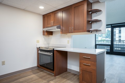 A kitchen with a white counter top and wooden cabinets.