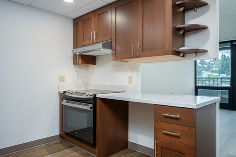 A kitchen with a white counter top and wooden cabinets.