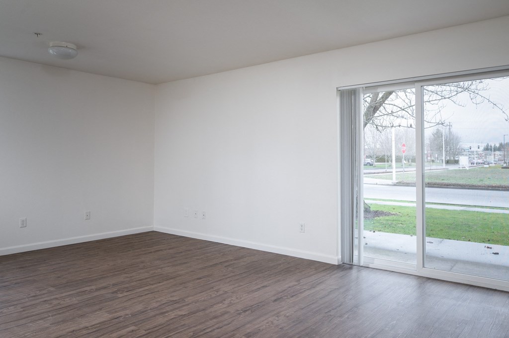 a bedroom with a sliding glass door and hardwood floors