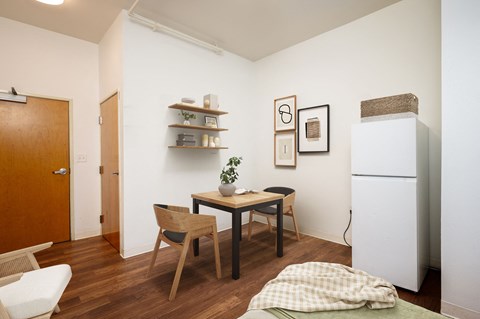 a small dining room with a table and chairs and a refrigerator