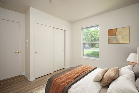 A bedroom with a bed, pillows, and a window.