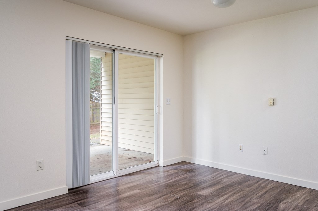 a bedroom with hardwood floors and white walls