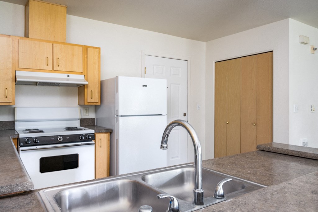 a kitchen with white appliances and wooden cabinets