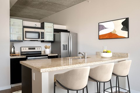 a kitchen with a marble counter top with three stools