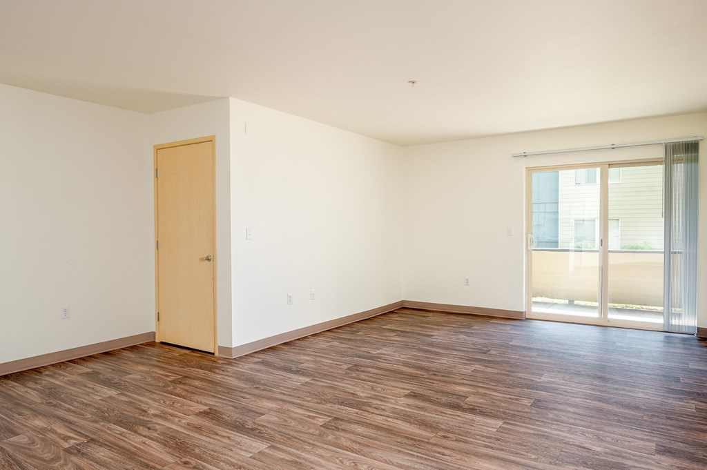 A room with a wooden floor and a sliding glass door.