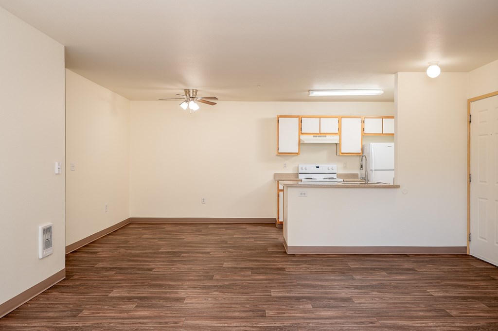 A room with wooden floors and a white ceiling with a fan.