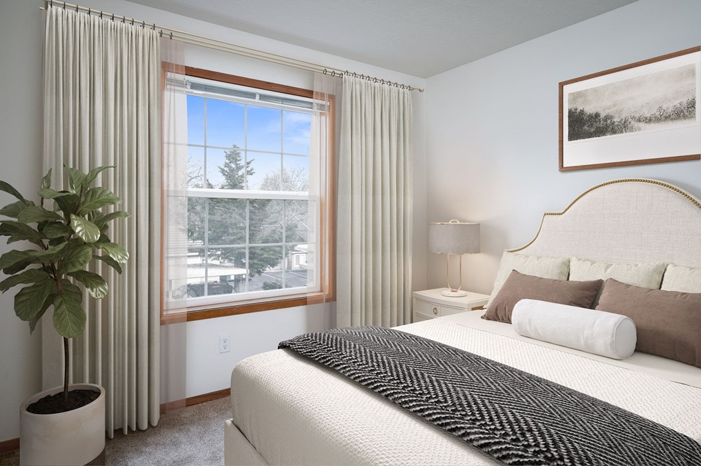 a bedroom with a large bed and a large window