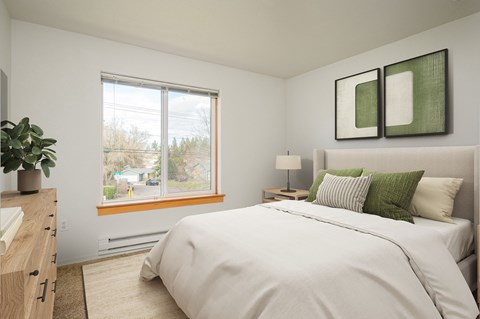 A bedroom with a large bed and a window overlooking a street.