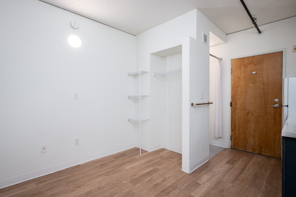 a bedroom with white walls and a wooden floor