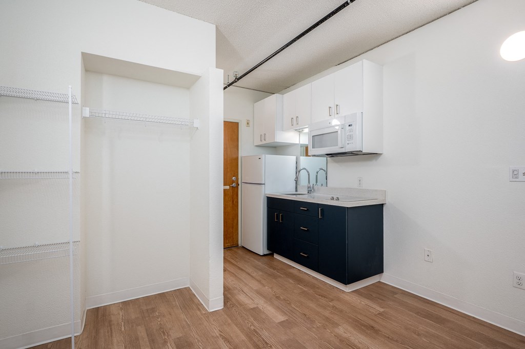 a kitchen with white cabinets and a dark blue island