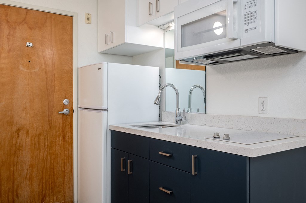 a kitchen with white appliances and black cabinets