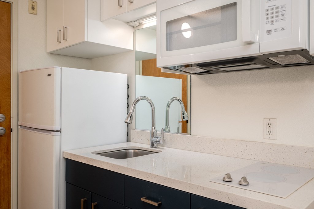 a kitchen with white cabinets and a white sink